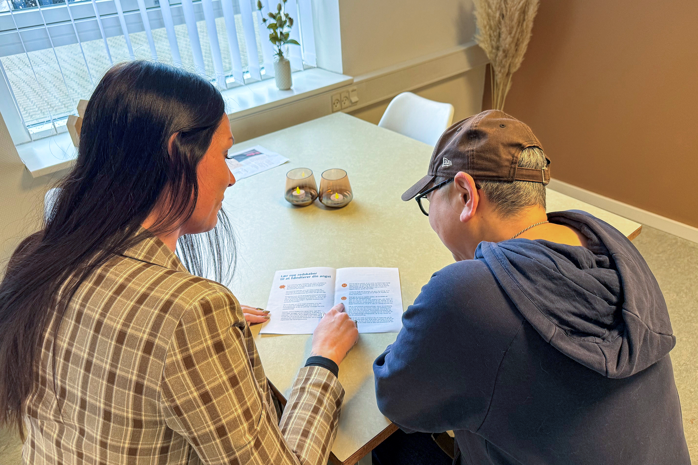 Foto af samtale mellem to personer i Det Sociale Pitstop