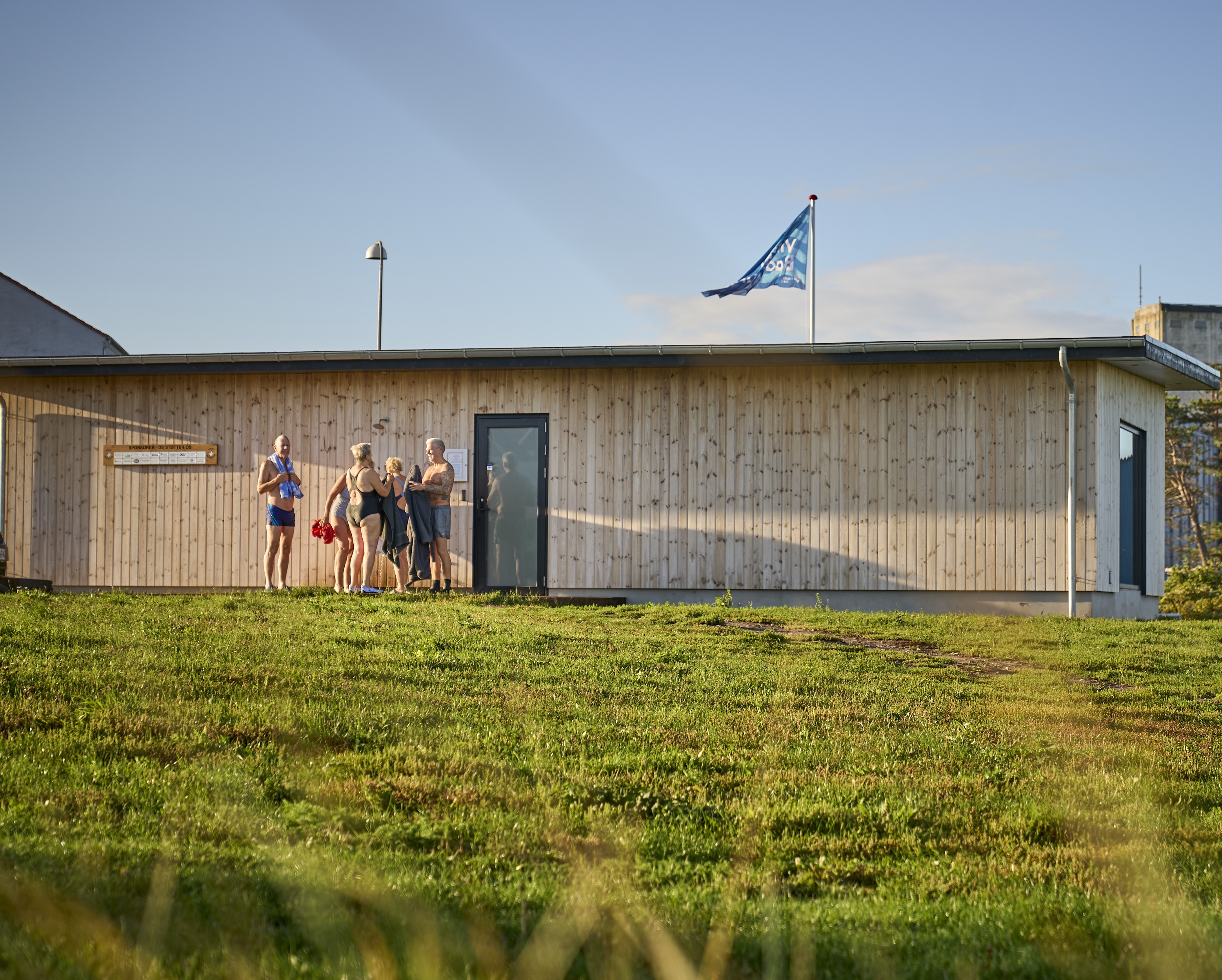 En gruppe badere står ude foran en stor sauna